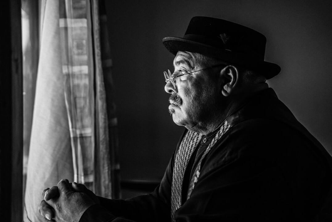 Studio portrait of a white Uruguayan man in his 50s, senior mystery writer, neutral background